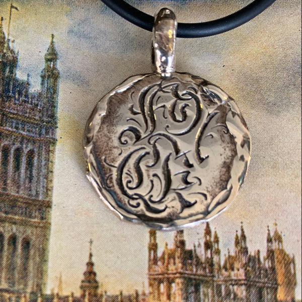 Wonky disc pendant by Ali Alexander. Handcrafted in sterling silver, engraved with the word “FUCK” for a bold, irreverent statement piece.