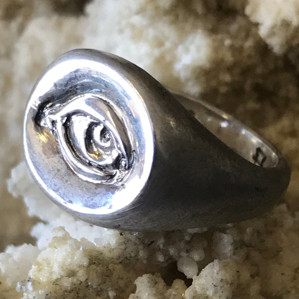 Evil Eye signet ring by Aimee Sutanto. Handcrafted in oxidised sterling silver, featuring a carved protective eye symbol with bold detail.