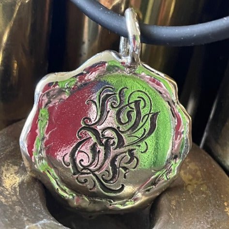 Wonky Love pendant by Ali Alexander. Handcrafted in sterling silver, featuring a playful, hand-engraved "LOVE" for a raw and heartfelt expression.