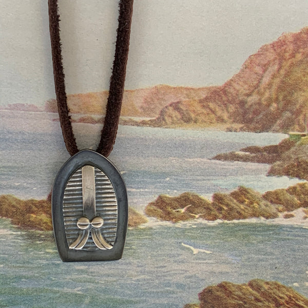 Guardian mask shield pendant by Gary Barnes. Handcrafted in sterling silver, featuring a bold tribal mask design for protection and strength.