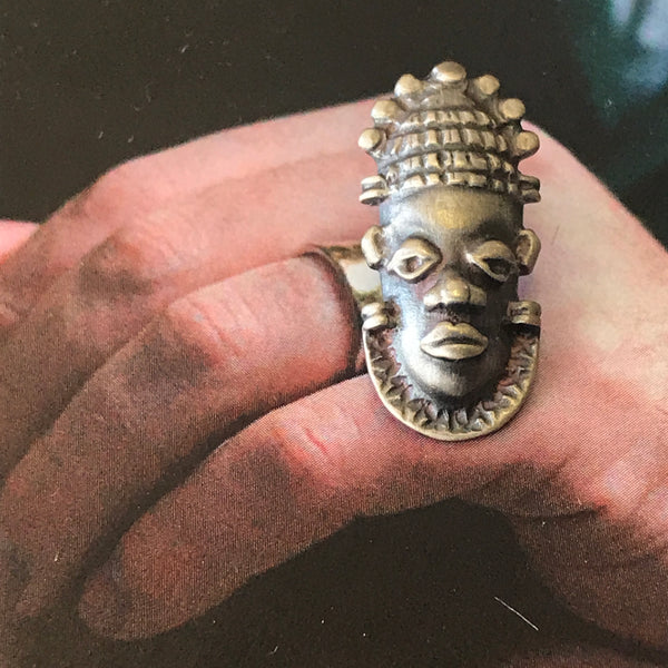 Tribal mask lapel pin by Gary Barnes. Handcrafted in oxidised sterling silver, featuring an intricately designed mask for a bold cultural statement.