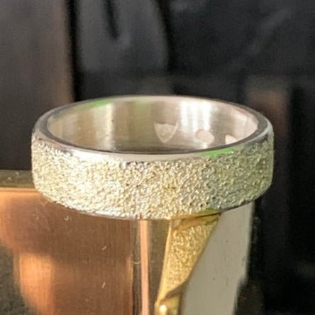 Golden Earth ring by Jeanette Dyke. Handcrafted in sterling silver with 18ct rose gold and black diamonds, featuring a textured design inspired by nature’s beauty.