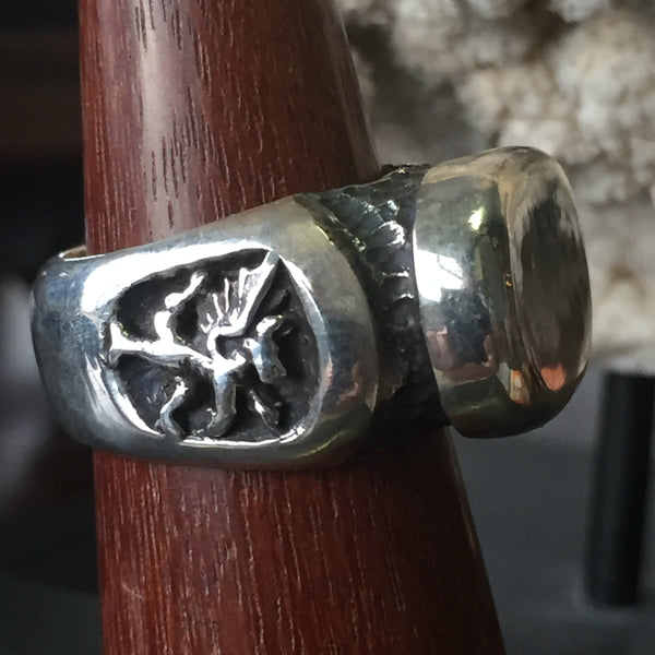 Dragon oval signet ring by Unnon. Handcrafted in sterling silver, featuring a detailed dragon design on the side of the ring for a bold, mythical look.