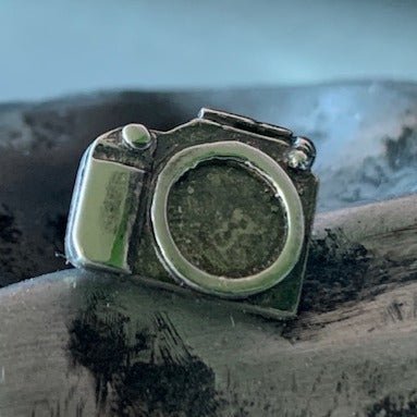 Camera lapel pin by Victoria Mason. Handcrafted in sterling silver, featuring a detailed camera design for a stylish accessory with a vintage touch.